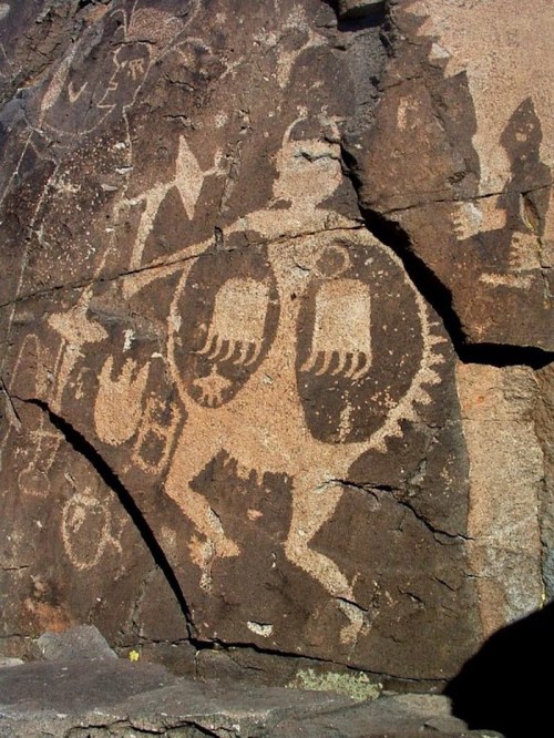 Petroglyphs on a rock surface depicting abstract figures and symbols, showcasing ancient artistic expression.