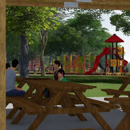 A park scene featuring picnic tables, trees, and a playground with colorful equipment in the background.