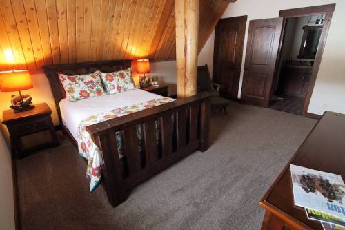 Cozy bedroom with wooden accents, floral bedding, two lamps, and a dresser in a warm, inviting atmosphere.