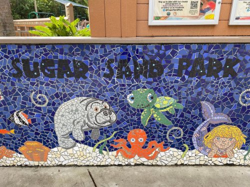 Colorful mosaic mural at Sugar Sand Park featuring sea creatures like a manatee, turtle, octopus, and fish.