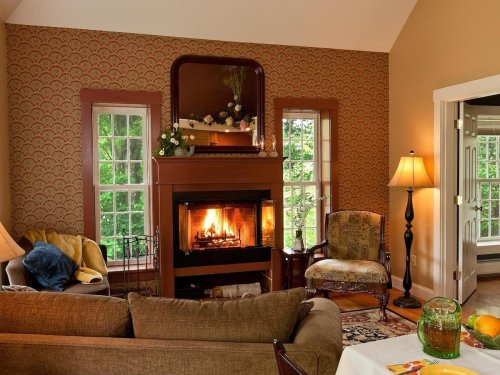 Cozy living room with a fireplace, comfortable seating, and large windows letting in natural light.