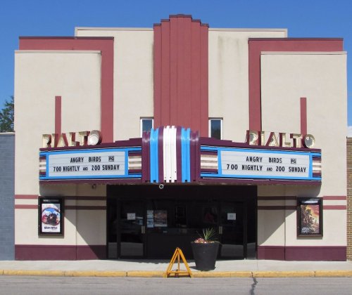 Exterior of the Rialto Theater featuring a marquee with showtimes for "Angry Birds." Bright, Art Deco style architecture.