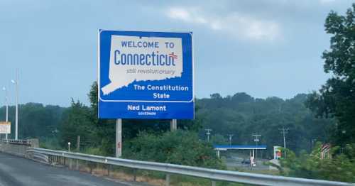 Welcome sign for Connecticut, featuring "The Constitution State" and Governor Ned Lamont's name.