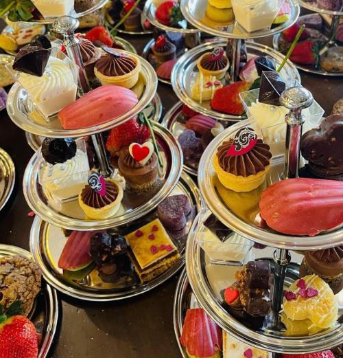 A tiered display of assorted desserts, including cupcakes, chocolates, and strawberries, beautifully arranged.
