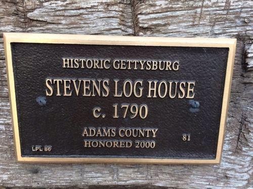 Plaque on a log house reading "Stevens Log House c. 1790, Historic Gettysburg, Adams County, Honored 2000."