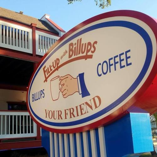 Sign for "Fill-Up with Billups Coffee" featuring a hand holding a coffee cup, with the tagline "Your Friend."