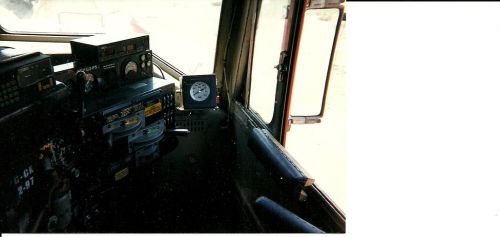 Interior view of a vehicle's dashboard, featuring gauges, controls, and a window.