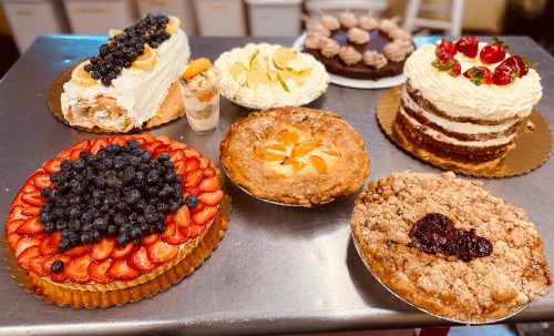 A variety of delicious desserts including fruit tarts, cakes, and pies displayed on a table.