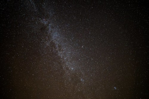 A starry night sky filled with countless stars and a faint galaxy band stretching across the darkness.