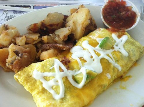 A plate featuring a cheese and vegetable omelet, seasoned potatoes, and a side of salsa.