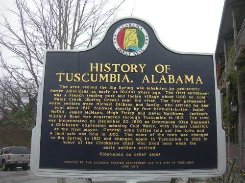 Sign detailing the history of Tuscumbia, Alabama, including early settlers and significant events from 1817 onward.