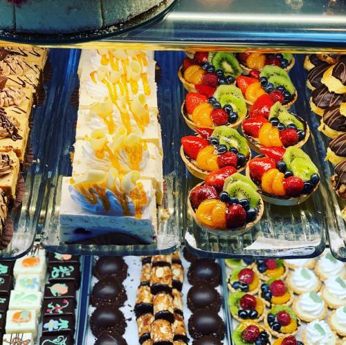 A display of assorted desserts, including fruit tarts, cream cakes, and chocolate treats.