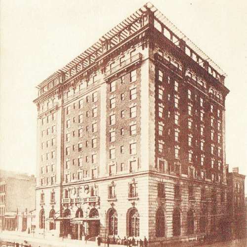 Historic building with a grand facade, featuring multiple stories, large windows, and a decorative entrance.