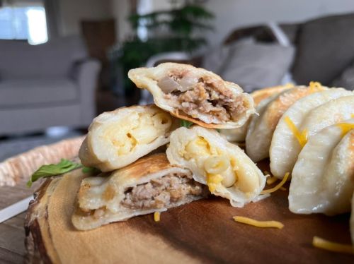 Close-up of stuffed pastries filled with meat and cheese, served on a wooden platter with a cozy background.