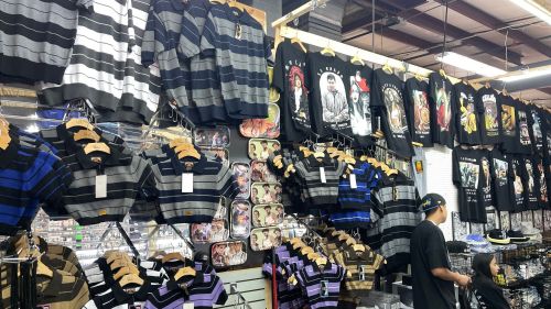 A clothing store display featuring striped shirts and graphic t-shirts hanging on racks.