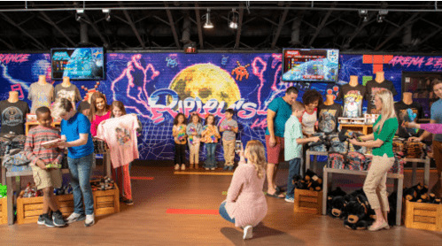 A vibrant store scene with families shopping for merchandise, colorful displays, and a disco-themed backdrop.