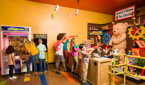 A colorful toy store with children playing games and a large teddy bear in the background. Fun and vibrant atmosphere.