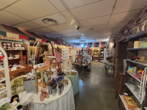 A cozy shop interior filled with various decorative items, shelves, and displays, creating a warm, inviting atmosphere.