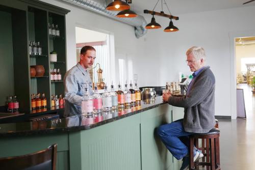 A bartender serves a customer at a stylish bar with various bottles displayed on the shelves.
