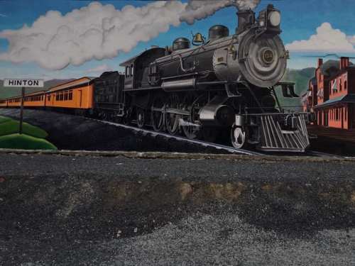 A vibrant mural of a steam locomotive with an orange train, set against a blue sky and buildings labeled "Hinton."