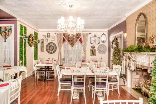 Cozy restaurant interior with elegant decor, tables set for dining, and festive holiday accents.