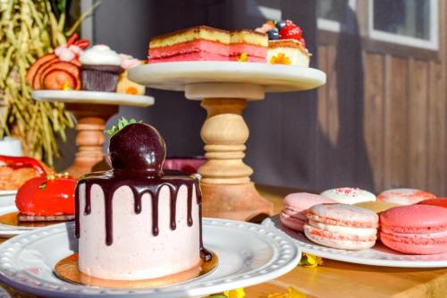 A variety of colorful desserts, including cakes, macarons, and pastries, displayed on elegant stands.