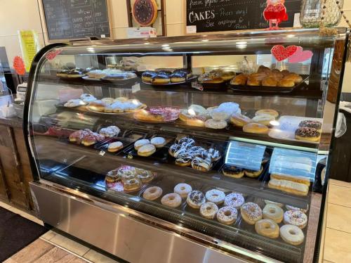 A display case filled with a variety of colorful donuts and pastries in a bakery.