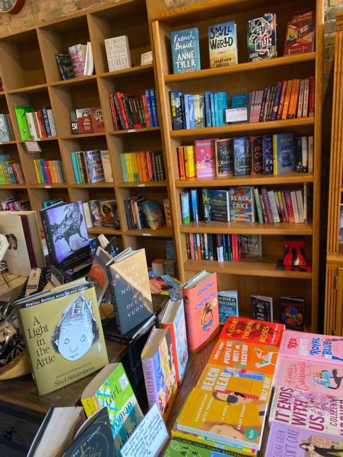 A cozy bookstore display featuring colorful books on shelves and tables, creating a warm reading atmosphere.
