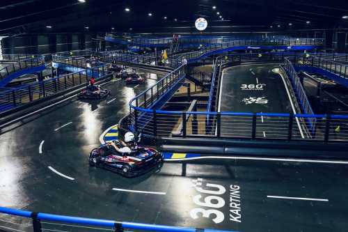 A vibrant indoor go-kart track with multiple levels and racers navigating the winding course.