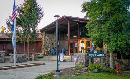 Exterior view of Tierney's Cavern restaurant, featuring stone architecture, a flagpole, and landscaped entrance.