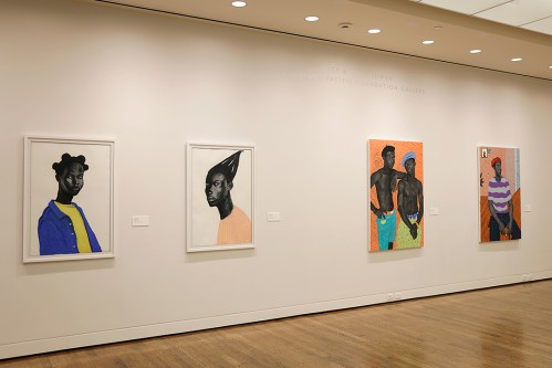 Four framed portraits of Black individuals displayed on a gallery wall, featuring vibrant colors and diverse styles.