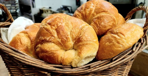 A woven basket filled with freshly baked golden croissants.