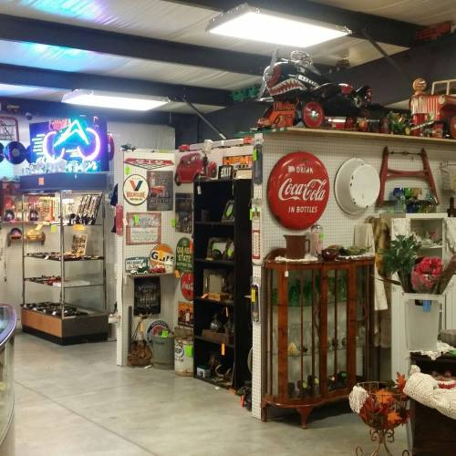 A vintage shop interior featuring retro signs, collectibles, and display shelves filled with various nostalgic items.