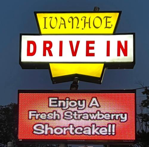 Sign for Ivanhoe Drive-In featuring bright yellow and red text promoting fresh strawberry shortcake.