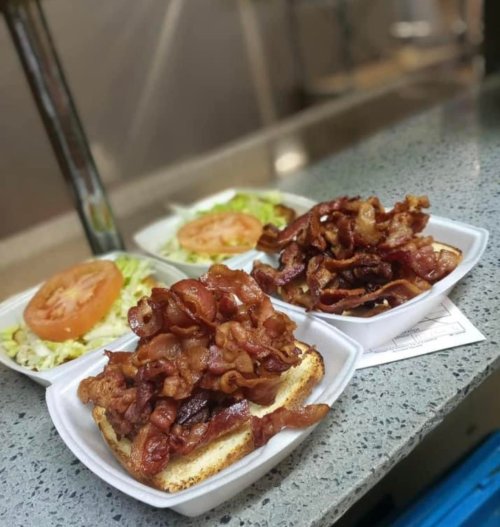 Three plates of food featuring toasted bread topped with a generous serving of crispy bacon, alongside lettuce and tomato.