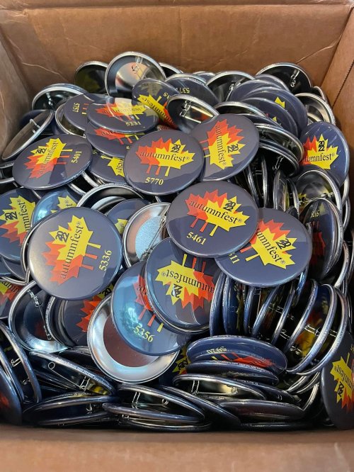 A box filled with colorful buttons featuring a design for "Autumnfest" with various numbers.