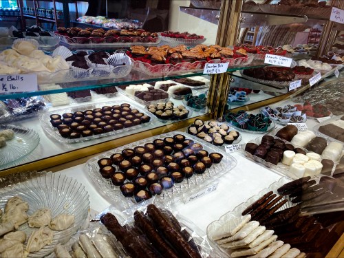 A display case filled with various chocolates and confections, including truffles, chocolate-covered treats, and candies.