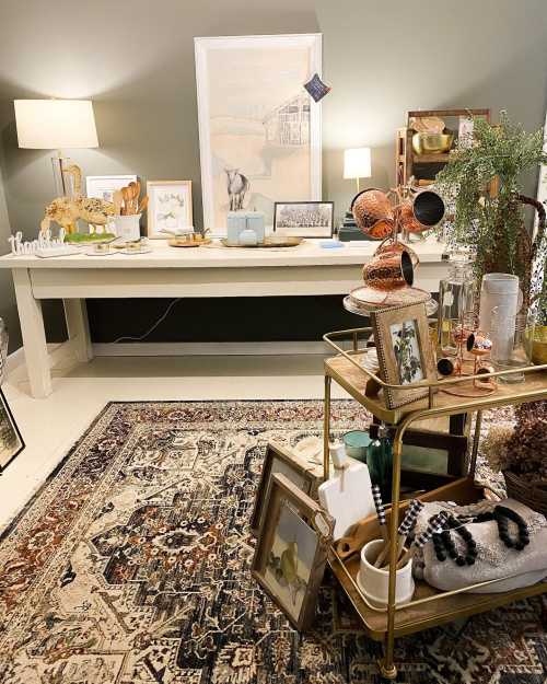 A cozy interior featuring a table with decor items, a rug, and a cart displaying various decorative objects.