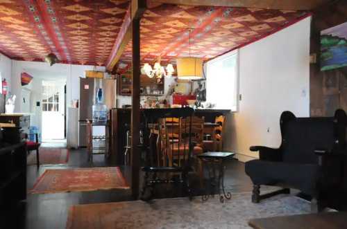 Cozy interior of a rustic home featuring a patterned ceiling, dining area, and comfortable seating.