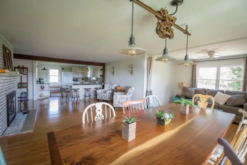 Bright, open living space featuring a dining table, cozy seating area, and modern kitchen in the background.