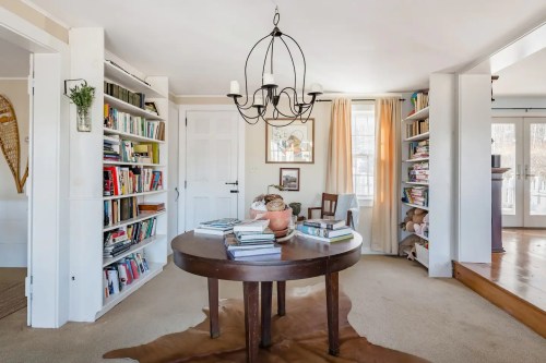 Cozy room with a round table, bookshelves filled with books, and a warm, inviting atmosphere.