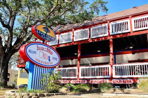 A colorful restaurant exterior with a sign reading "Live Oak Lounge" and "Billups Coffee" under a clear blue sky.