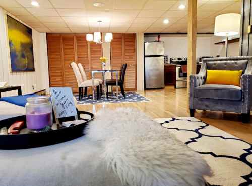 Cozy living space featuring a dining area, kitchen, and comfortable seating with decorative rugs and warm lighting.