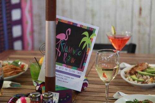 A table set with colorful drinks and dishes, featuring a menu for "Flamingo Row" with tropical decor.