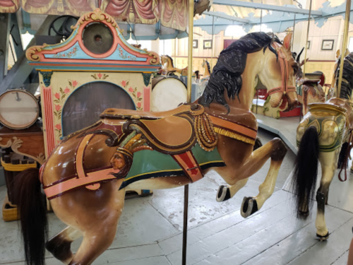A vintage carousel horse with a colorful saddle, set in a charming carousel environment.