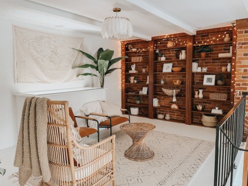 Cozy living space with a map, plants, wooden shelves, and stylish furniture, creating a warm, inviting atmosphere.
