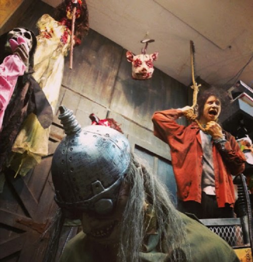 A spooky scene featuring creepy dolls and figures hanging in a dimly lit room, creating a horror atmosphere.