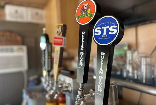 Close-up of beer taps featuring Blind Pig and STS Pils from Russian River Brewing Company.