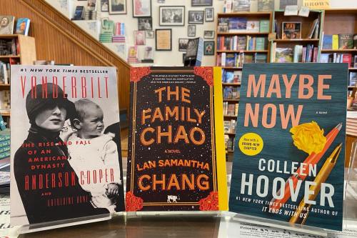 Three books displayed on a shelf in a bookstore: "Vanderbilt," "The Family Chao," and "Maybe Now."