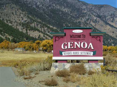 Welcome sign for Genoa, Nevada's oldest settlement, surrounded by mountains and autumn foliage. Established 1851.